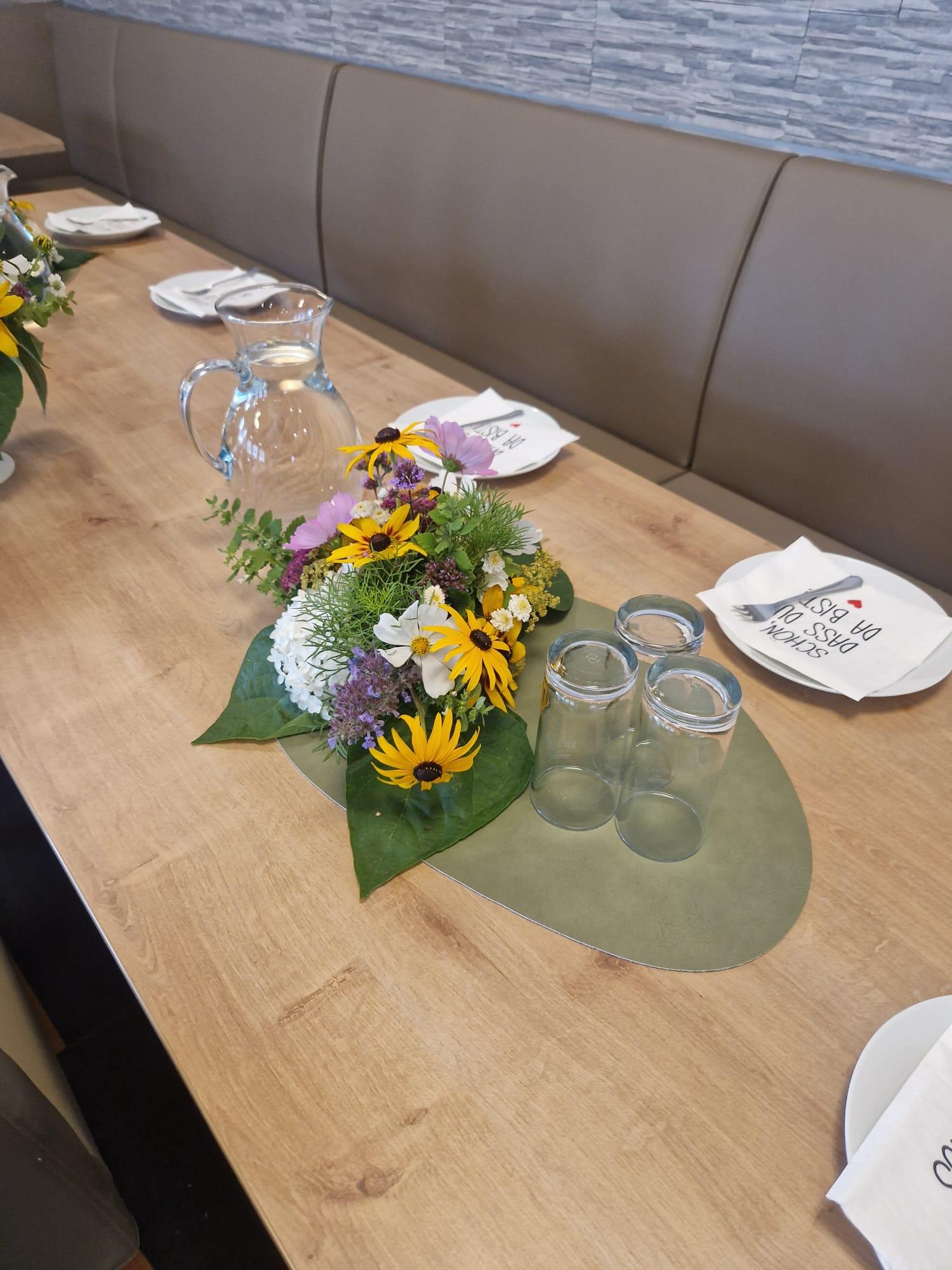 Tischdekoration mit Wiesenblumen und Wasserkrug