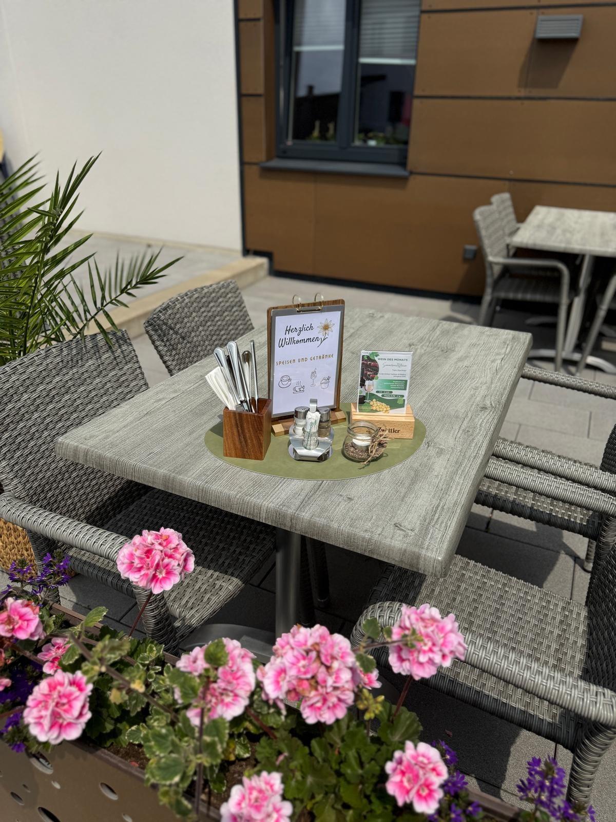 Terrasse mit Geranien und gedecktem Tisch